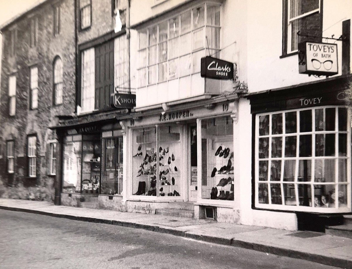 J. E. Hooper’s shoe shop at No. 10, with footwear in the windows and Clarks and K Shoes signs above. The photograph’s date is not stated.